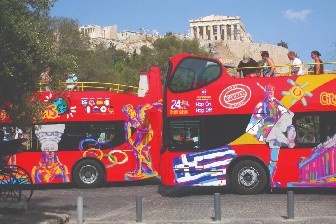 An image of two tour buses passing in Athens, Greece.