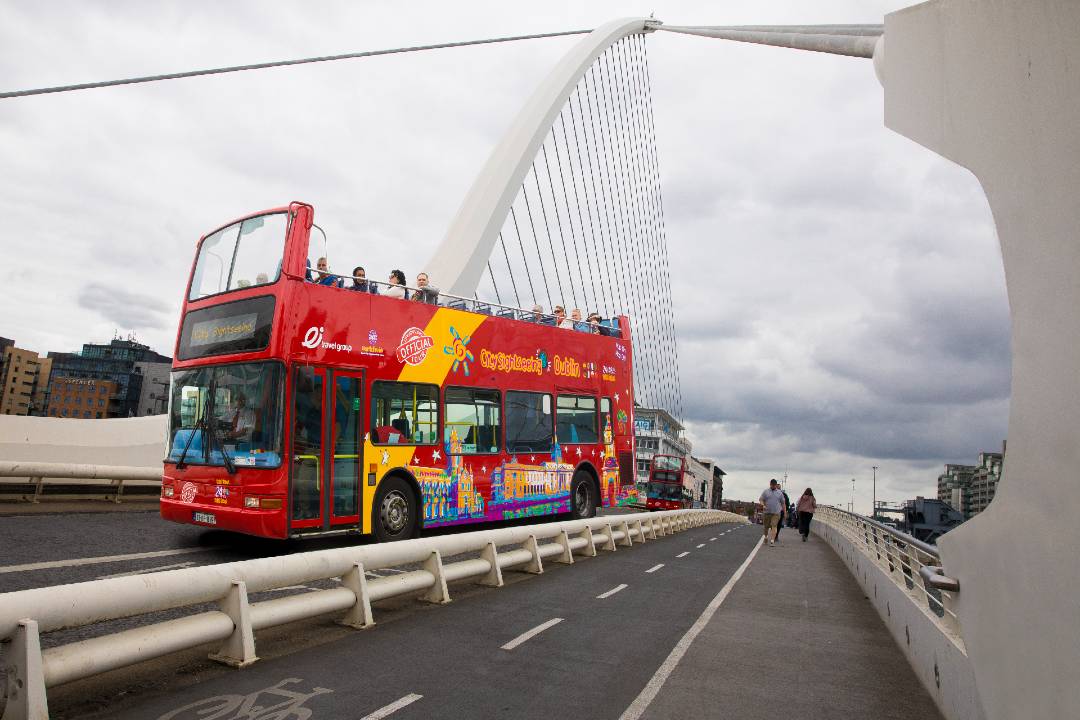 A Dublin tour bus driving across the Samuel Beckett Bridge.