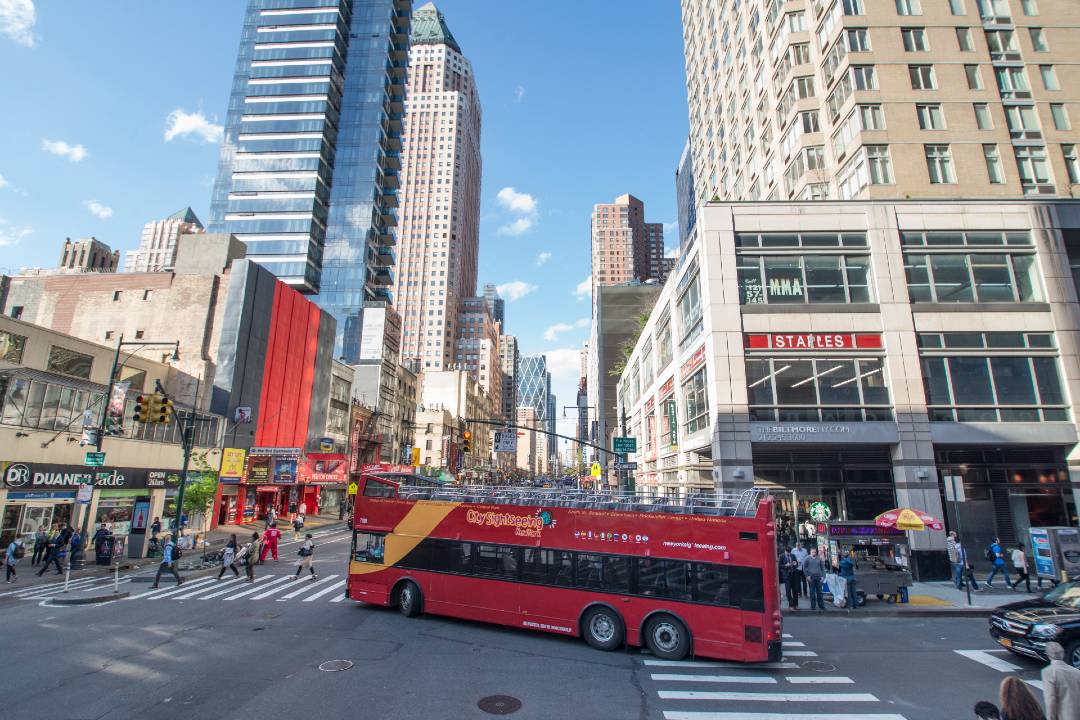 A tour bus driving down the streets of New York.