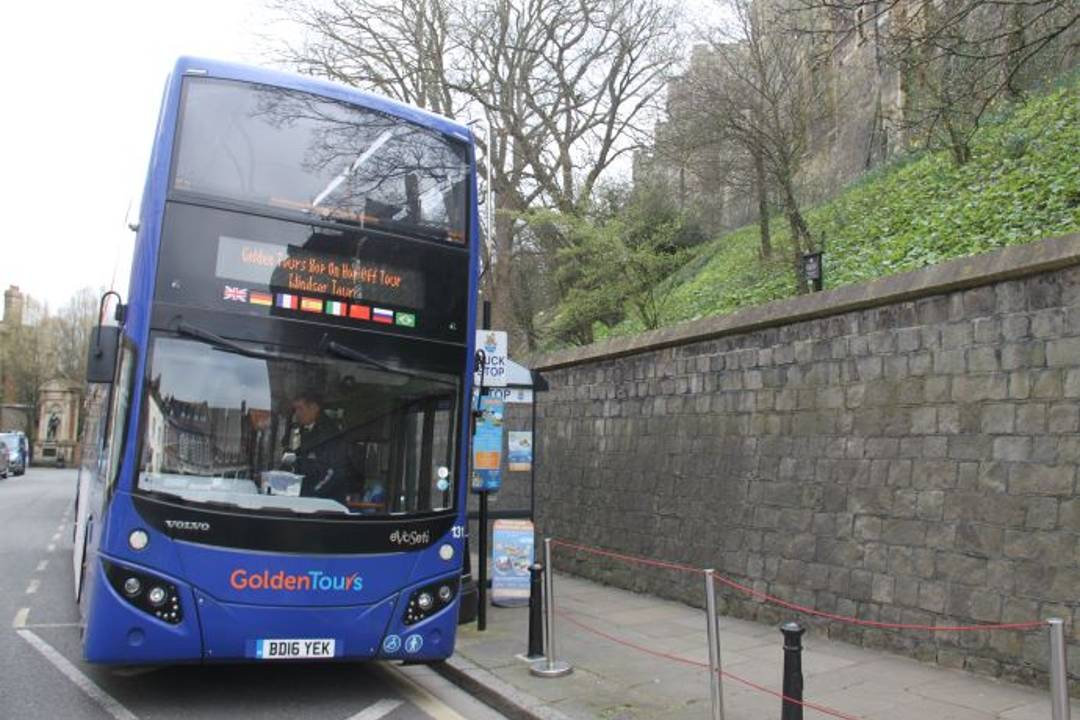 A Windsor bus tour waiting to pick up passengers at a bus stop.