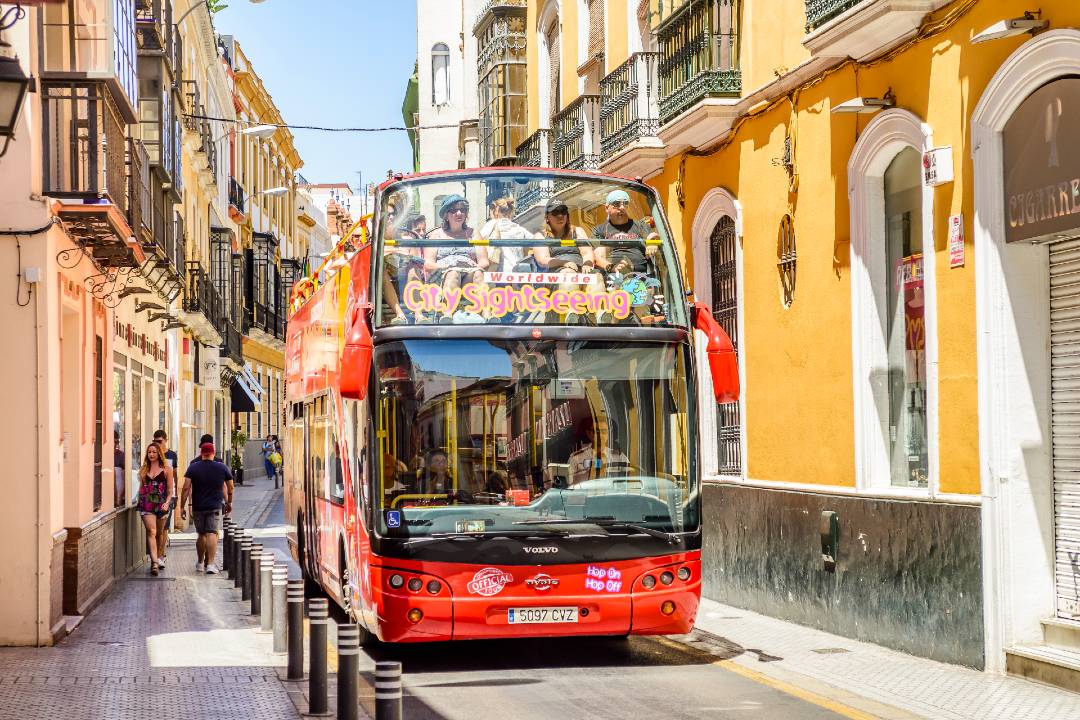 A Seville bus tour driving through the streets.