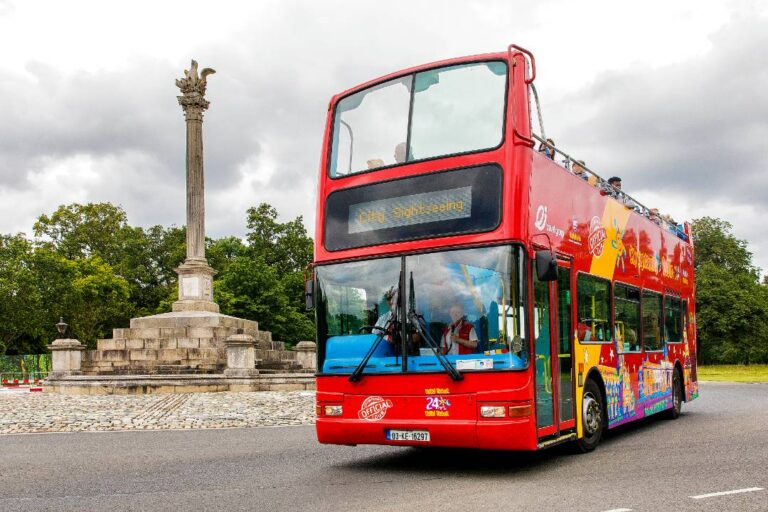 A hop-on hop-off Dublin bus tour driving past a column.