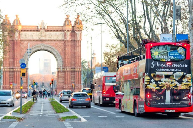 A bus tour driving towards the Arc de Triomf in Barcelona.