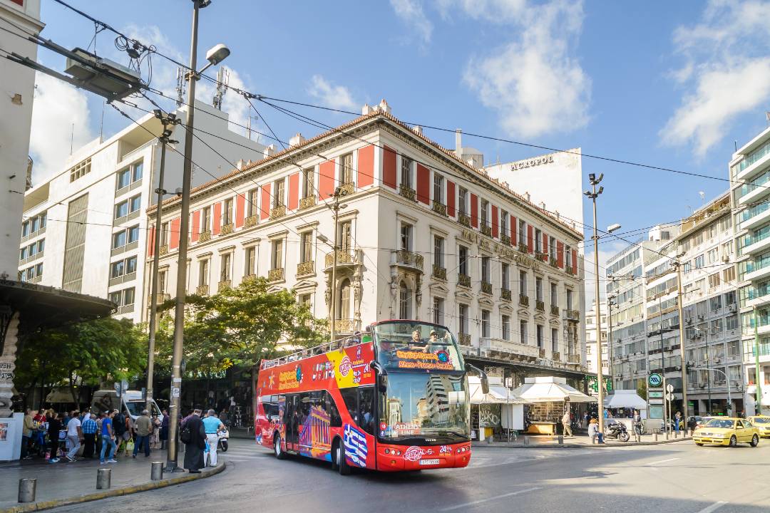 A hop-on hop-off Athens bus tour driving through the city.