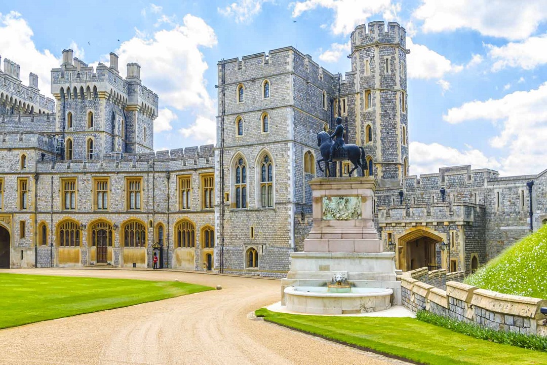 A photo from the front of Windsor Castle showing a statue of a man on a horse.