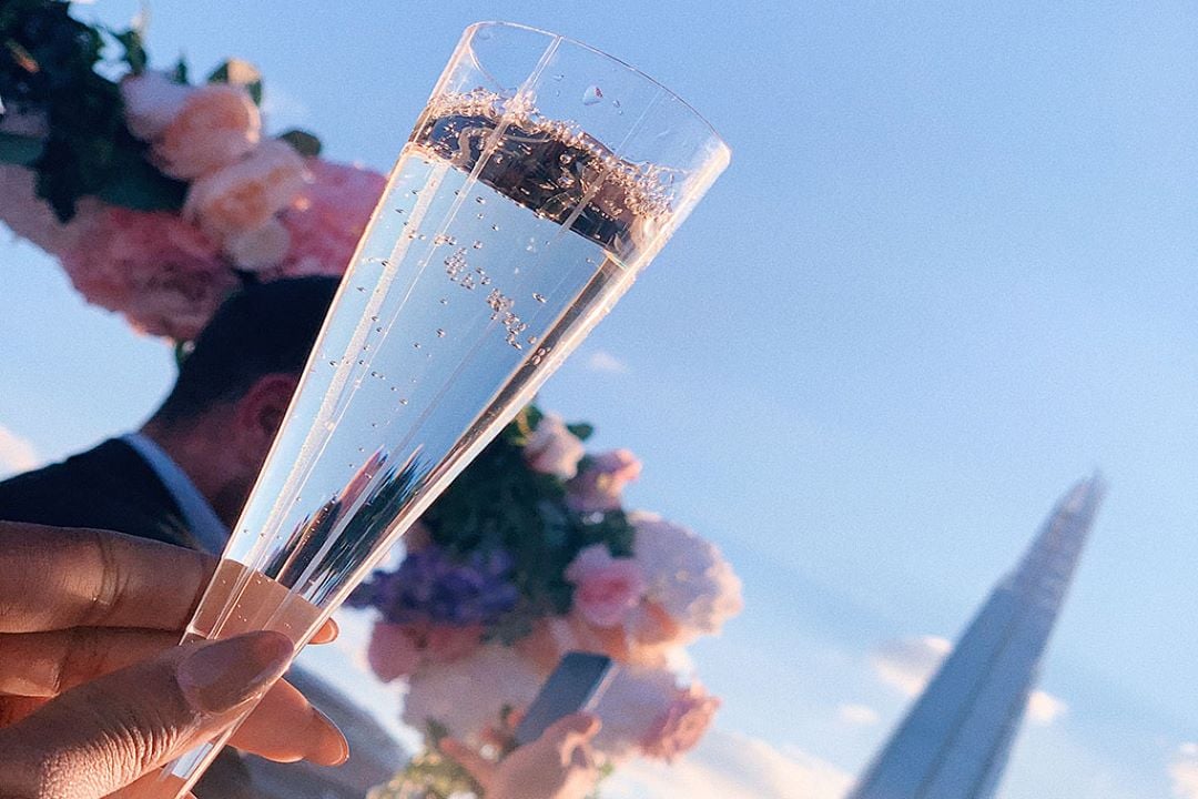 A photo of a glass of champagne with the Shard in the background.