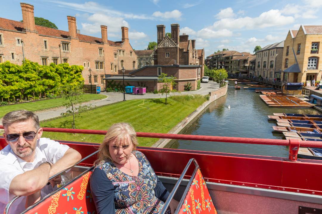 A photo of people on top of a Cambridge bus tour.