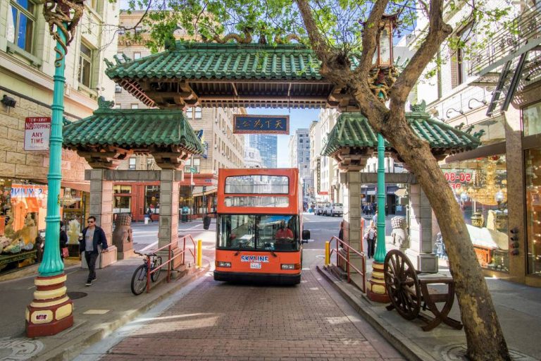 A photo of a San Francisco bus tour passing through the Chinatown Gate.