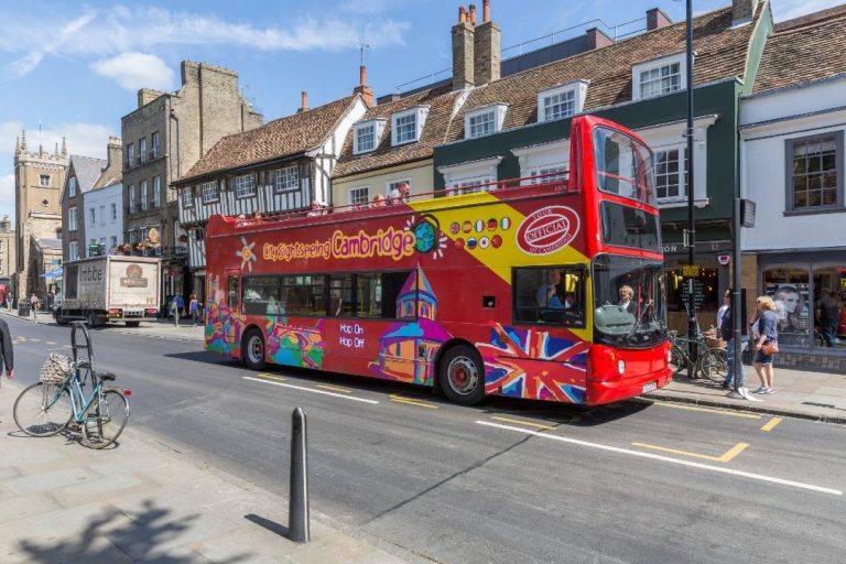A bus tour driving through Cambridge.