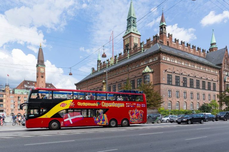 A bus tour driving past Copenhagen city hall.