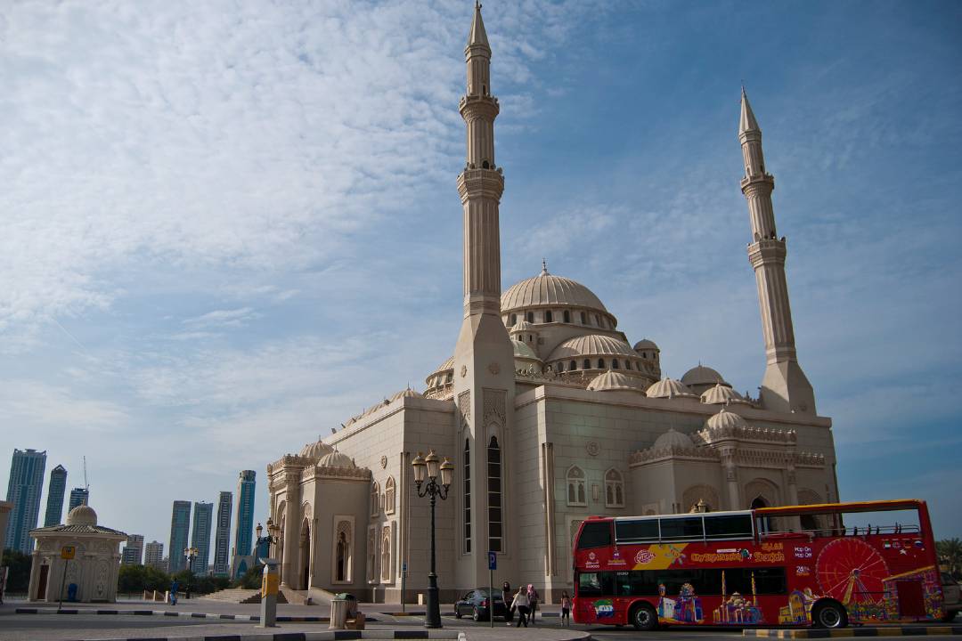 A photo of a bus tour in Sharjah passing the Al Noor Mosque.