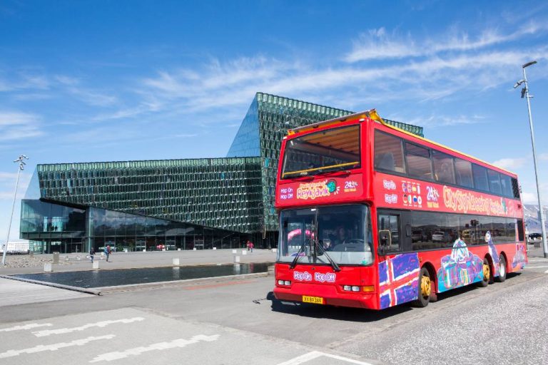 A Reykjavik Bus Tour passing by the Harpa Concert Hall.