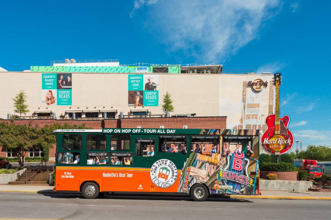 A bus tour driving past the Hard Rock Café in Nashville.