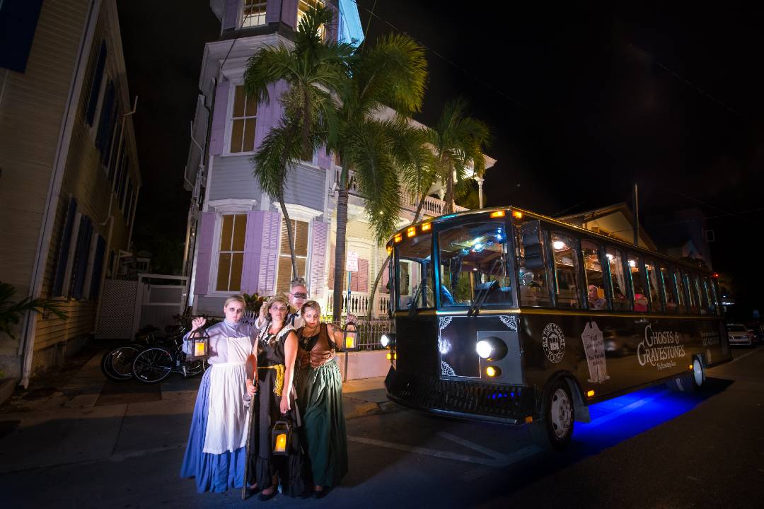 A photo of actors standing in front of a Key West ghost tour.