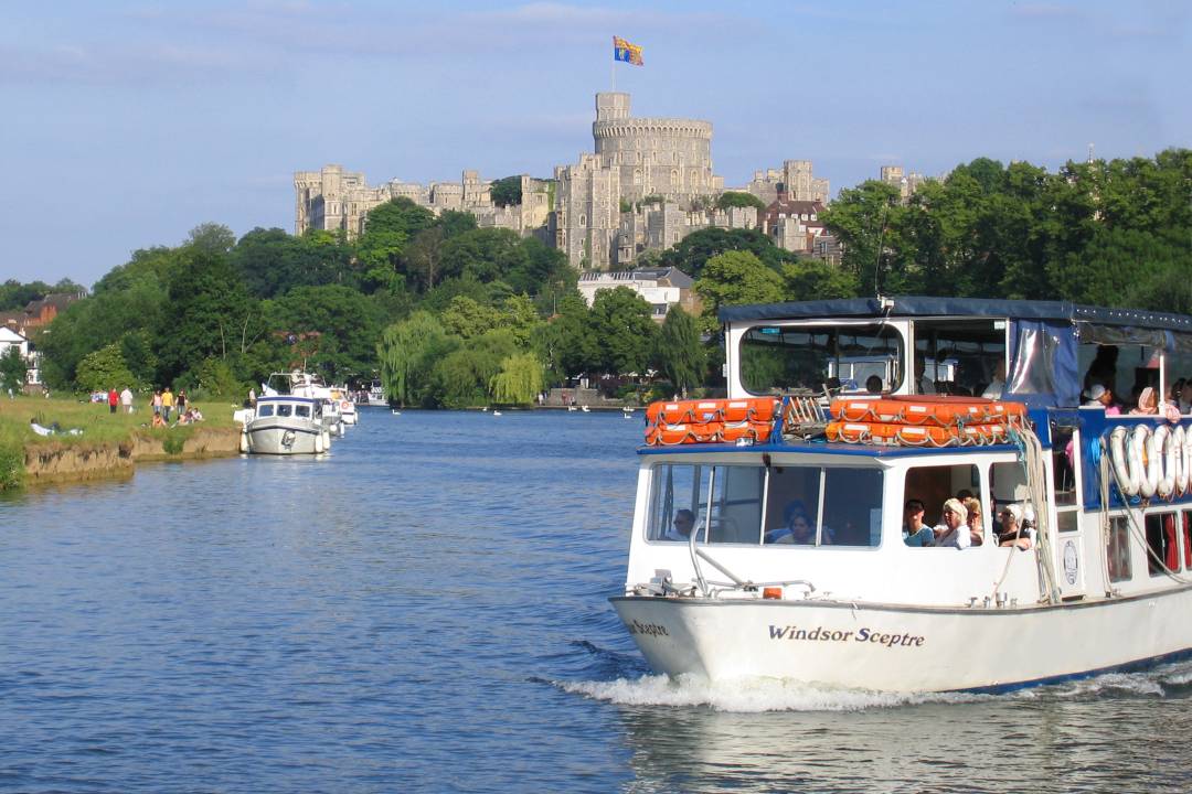 A photo of a Windsor boat trip with Windsor castle in the background.