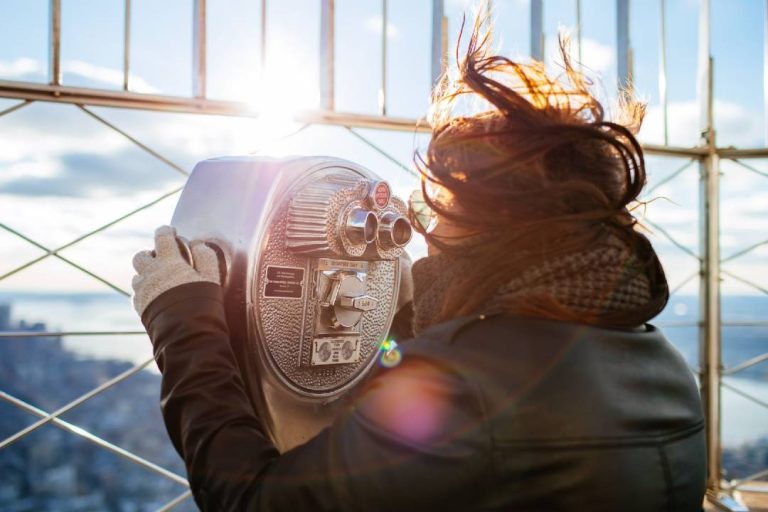 A photo of a woman looking through binoculars.