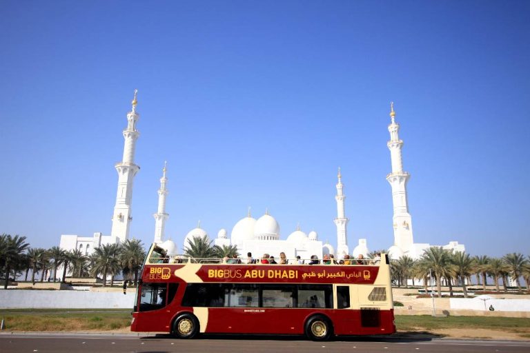 An Abu Dhabi hop-on hop-off bus tour passing the Grand Mosque.