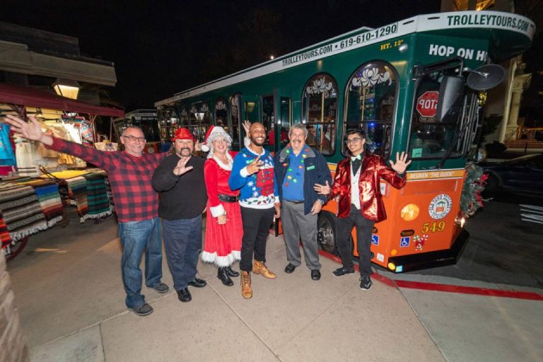 A photo of people in front of a trolley in San Diego.