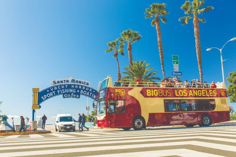 A photo of a Los Angeles bus tour passing by Santa Monica pier.