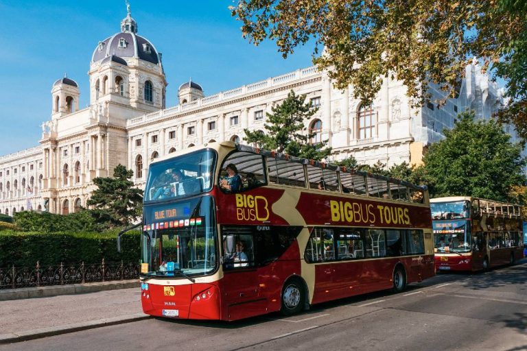 A photo of a bus tour passing the Museum of Natural History in Vienna.